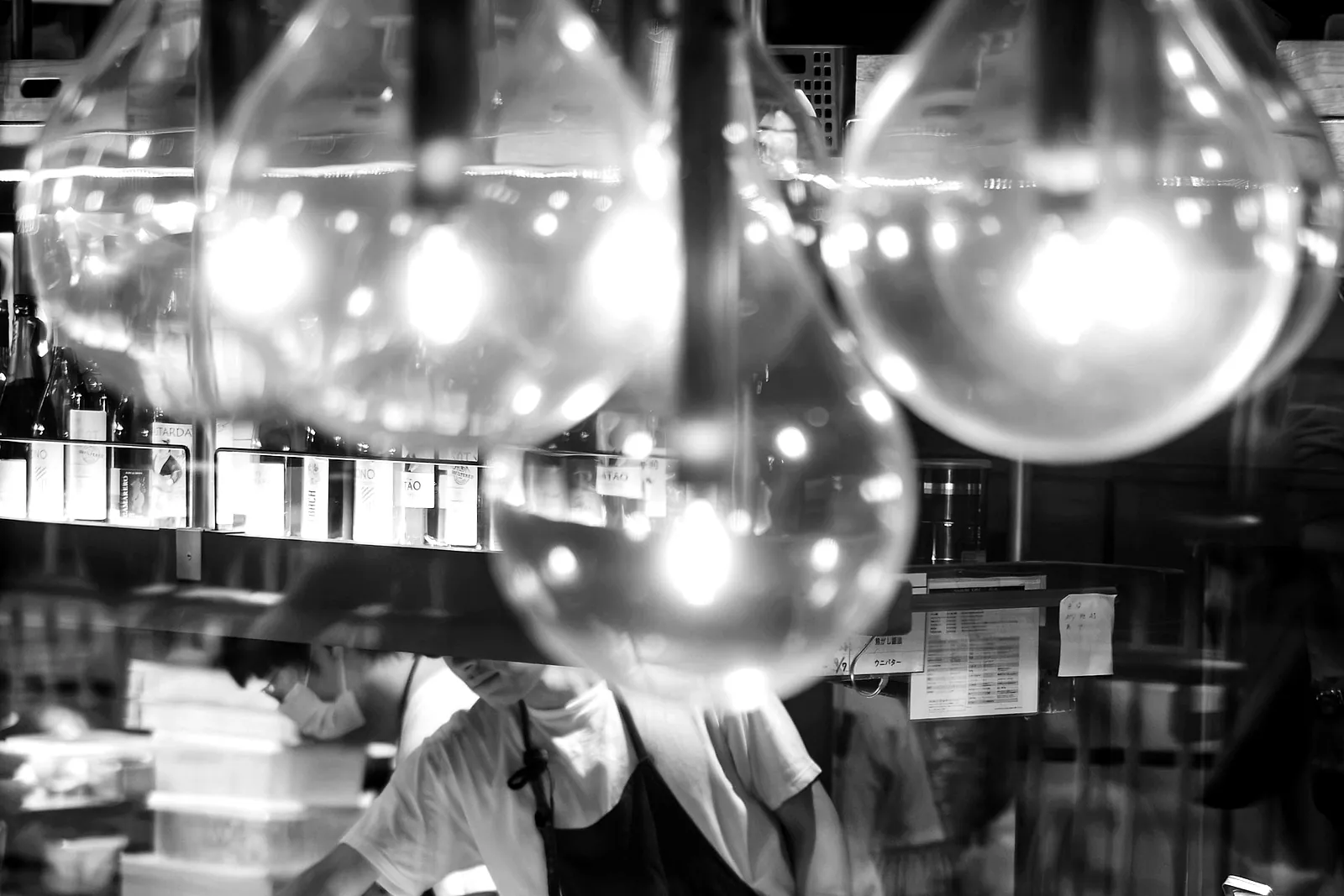A chef at the pass, working behind the counter under warm lights