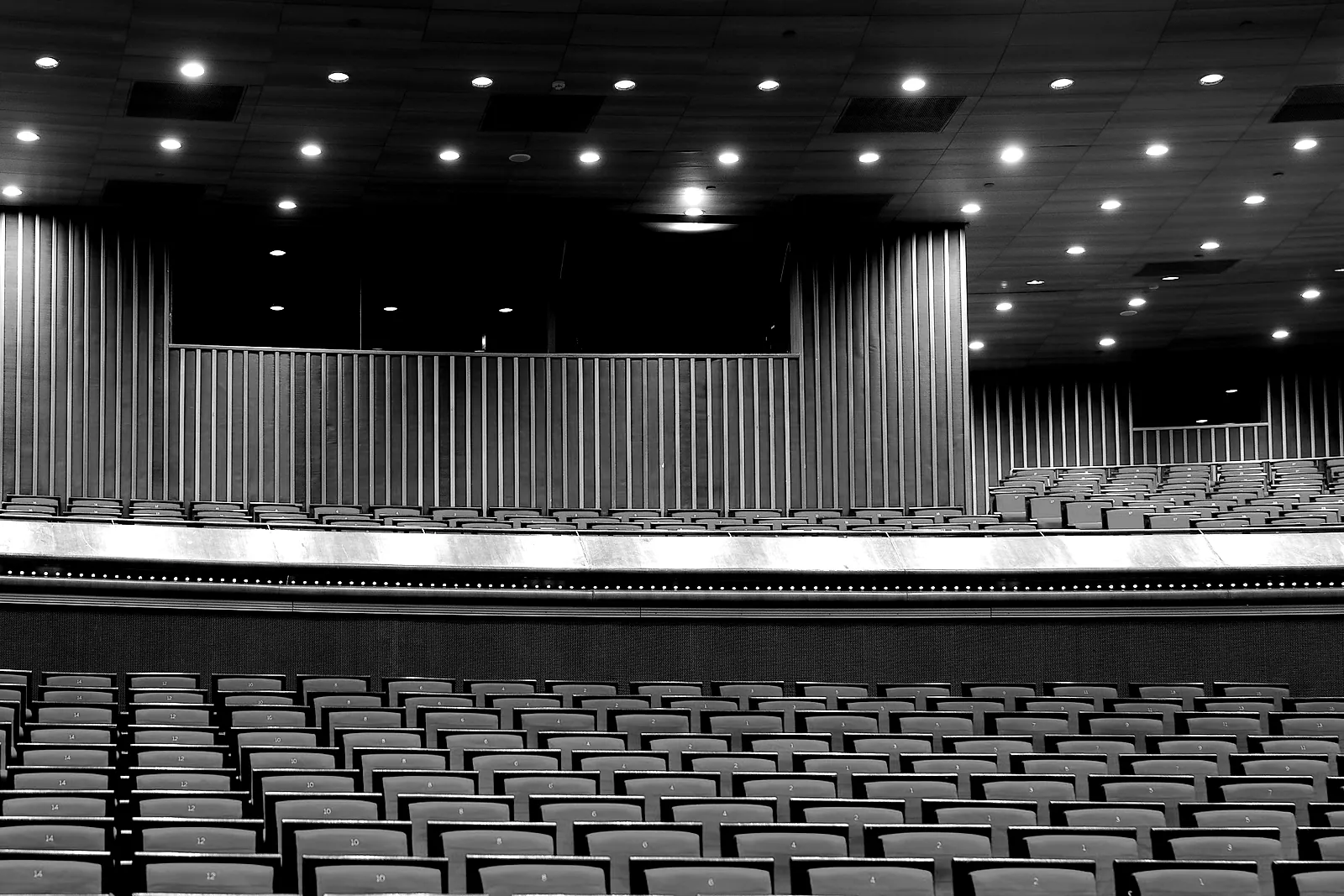 An empty auditorium, red seats facing the stage before doors open